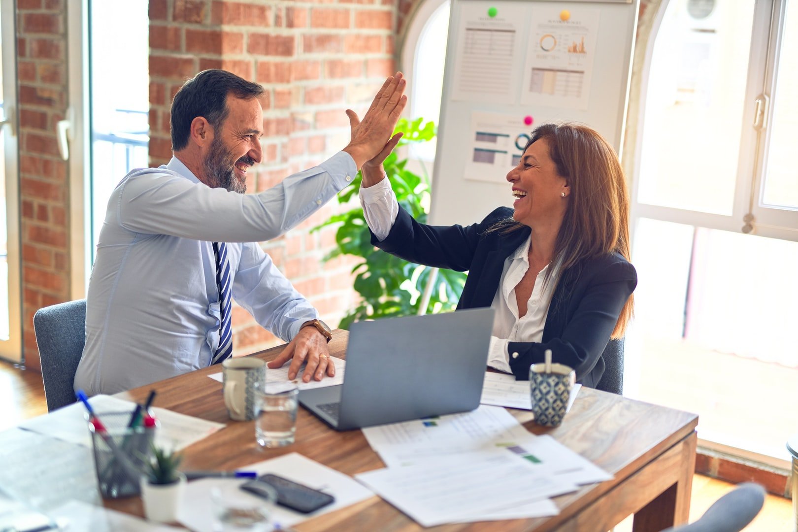 High-fiving colleagues in an office